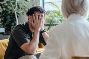 Man seeking support in therapy, expressing emotions during an indoor counseling session.